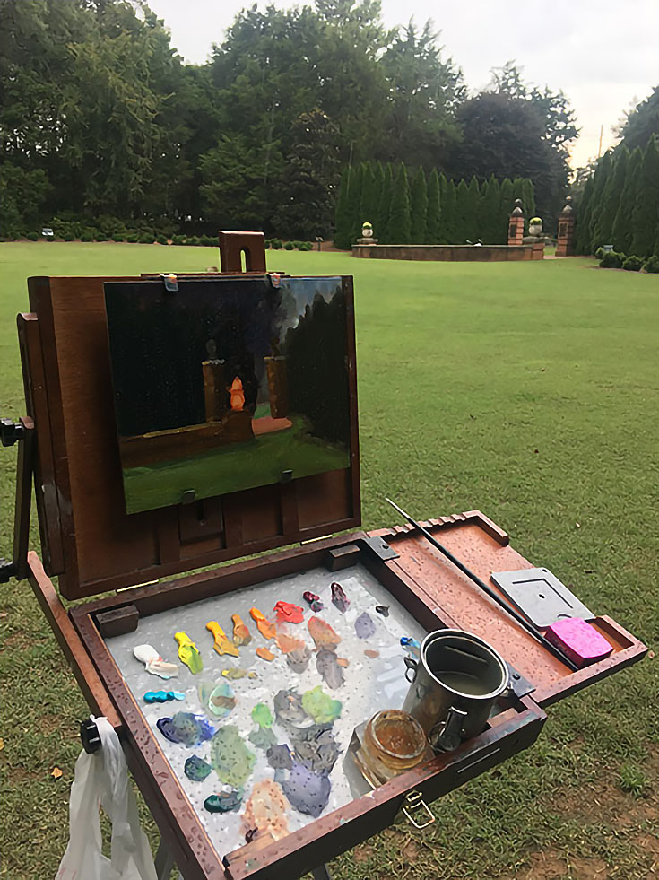 Plein air painting setup with pochade box easel and paints