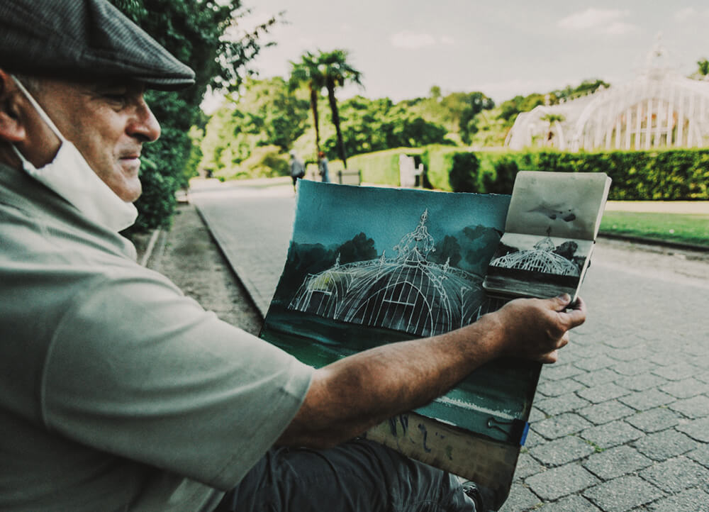 Painter looking at their painting next to reference material